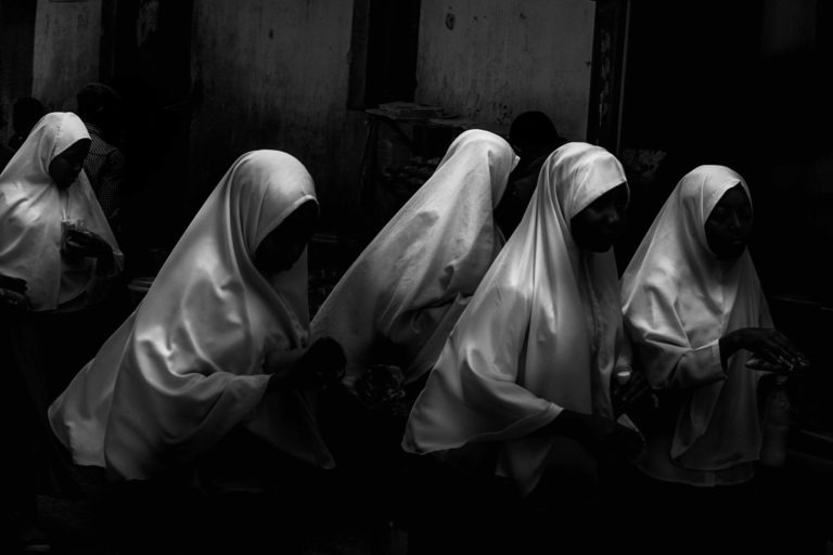 Cette photo représente un groupe de femmes voilées dont le visage disparaît dans l'ombre.